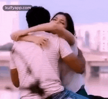 a man is carrying a woman on his back while they are hugging each other .