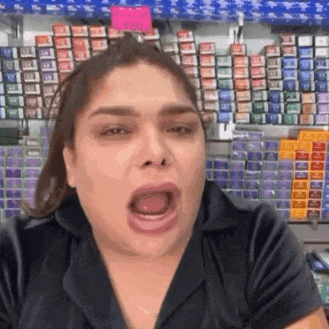 a woman is making a funny face in front of a row of hair dye .