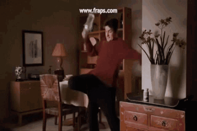 a man is kicking in a living room with the website www.frps.com displayed in the corner
