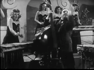 a black and white photo of a man playing a piano