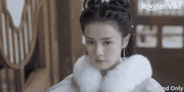 a woman is wearing a white fur coat with rakuten viki written in the corner