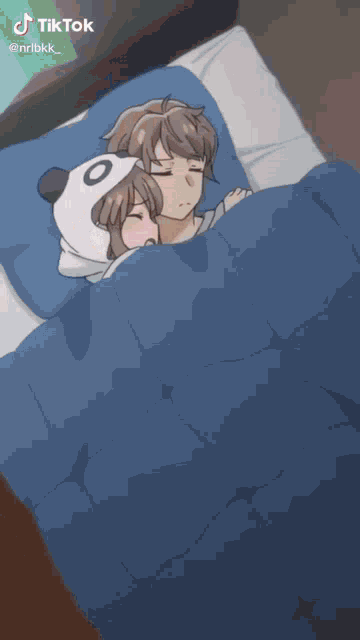 a girl wearing a panda hat is sleeping next to a boy in a bed .