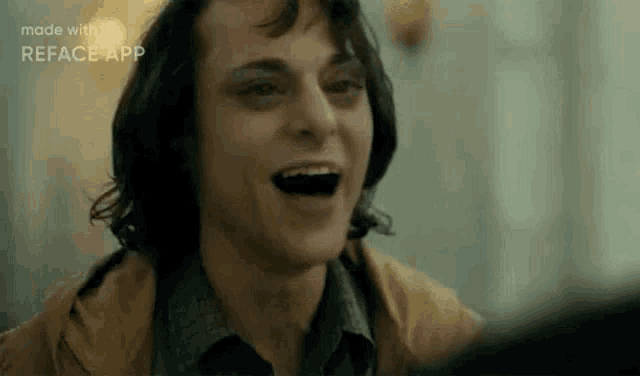 a close up of a man laughing with his mouth open in a movie scene .