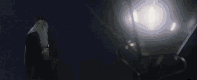 a man in a cape is holding a flashlight in his right hand