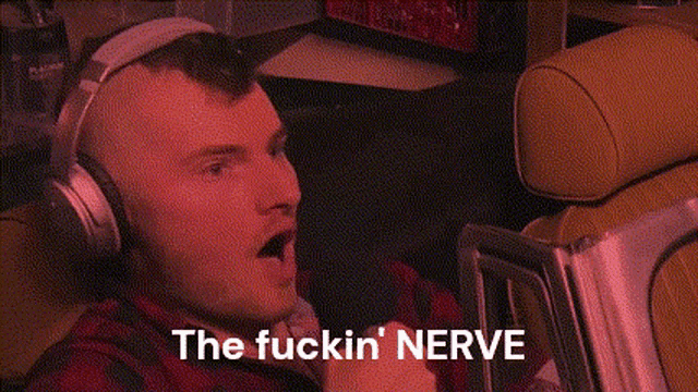 a man wearing headphones with the words " the fuckin nerve " on the bottom