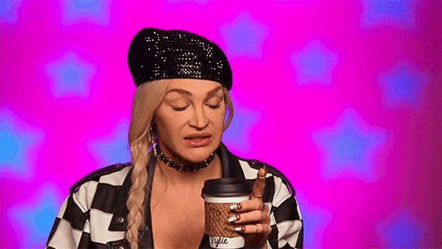 a woman is holding a cup of coffee in her hand .