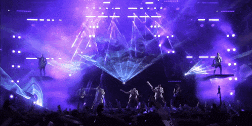 a group of people on a stage with a purple background
