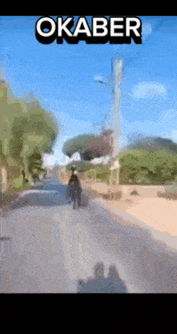 a blurry picture of a person riding a horse with the word okaber on the bottom right