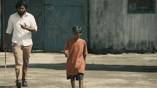 a man and a boy are walking in front of a building that has a sign that says ' smoking ' on it