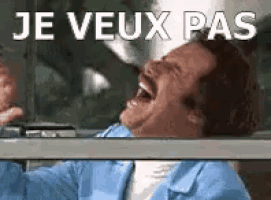 a man in a blue jacket is laughing with the words je veux pas written above him