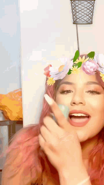 a woman with pink hair wearing a flower crown