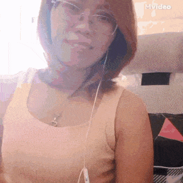 a woman wearing glasses and headphones is smiling in a mvideo screenshot