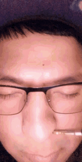 a close up of a man 's face with glasses and a small bug on his forehead
