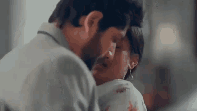 a man and a woman are kissing and hugging each other .