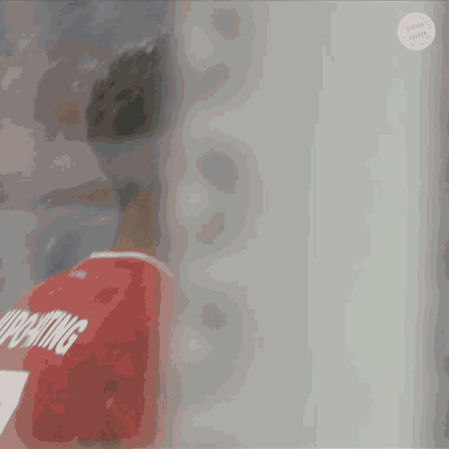 a blurred image of a soccer player wearing a red jersey with the number 7 on the back .
