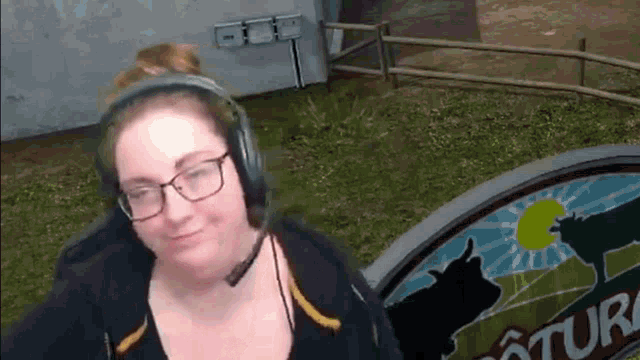 a woman wearing headphones and glasses is playing a video game .