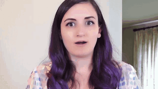 a woman with purple hair making a funny face