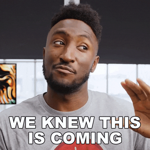 a man with a beard is wearing a gray shirt that says we knew this is coming
