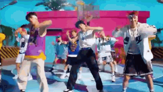 a group of young people are dancing on a basketball court .