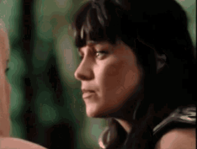 a close up of a woman 's face with a serious look on her face and a green background .