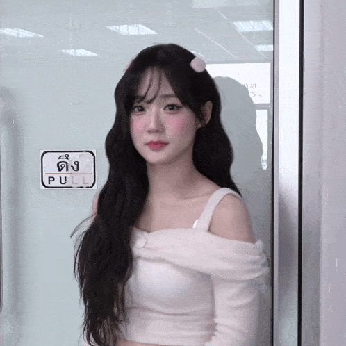 a woman stands in front of a door with a pull sign on it