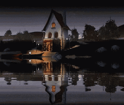 a house is reflected in a lake at night