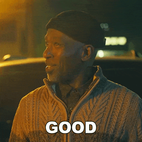 a man wearing a hat and sweater is smiling and says good