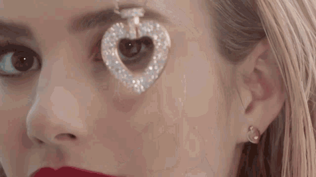 a close up of a woman holding a necklace