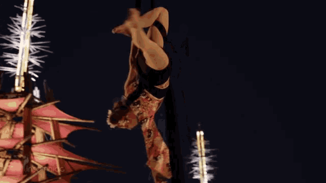 a woman is hanging upside down in the air with her legs crossed
