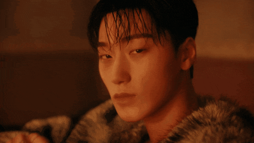 a man wearing a fur coat drinks from a glass