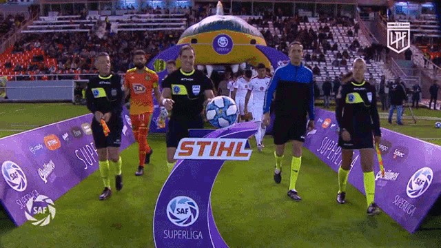 a group of soccer players are standing in front of a stihl sign