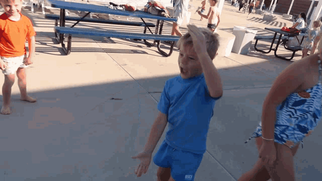 a boy wearing a blue shirt that says kc on the front
