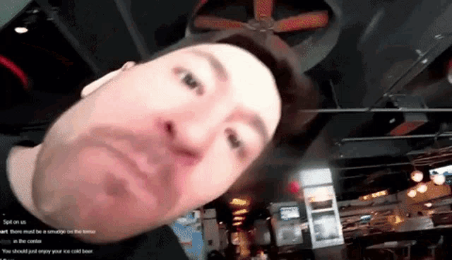 a man with a beard is making a funny face in a restaurant .