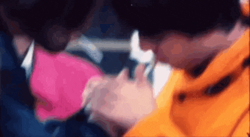 a close up of a person holding another person 's hand while wearing a mask .