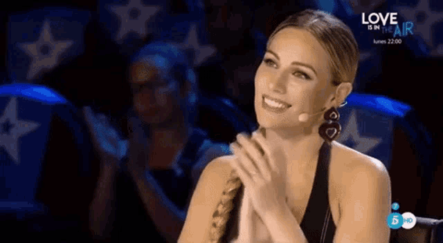 a woman sitting in front of a microphone with love in the air written on the bottom