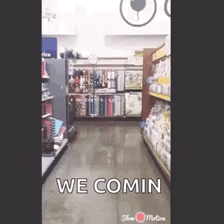 a person is walking down a aisle in a store with the words `` we comin '' written on the floor .