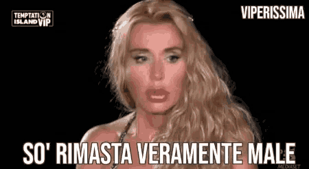 a woman with long blonde hair is making a funny face and says `` so ' rimasta veramente male '' .