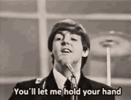 a man is singing into a microphone in a black and white photo .