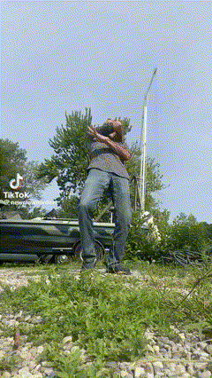 a man standing on top of a grassy hill with a tik tok logo on the bottom
