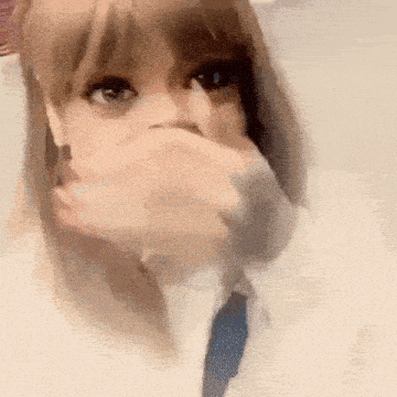 a woman is covering her mouth with her hand while wearing a white shirt and tie .