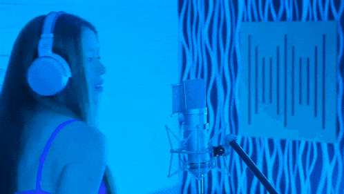 a woman singing into a microphone with the words tiene nombre de persona buena written above her