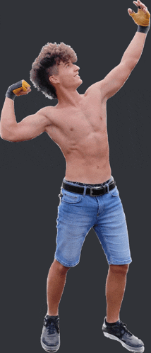 a shirtless young man flexes his muscles while wearing shorts