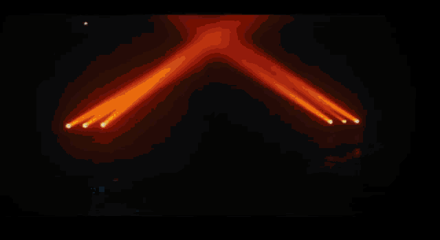 a silhouette of a person standing in front of a row of lights