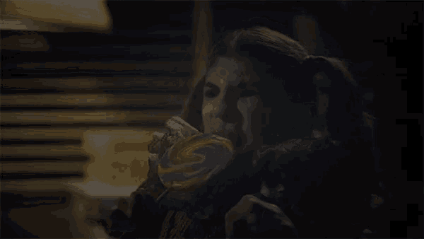 a woman is eating a colorful lollipop with a s on it