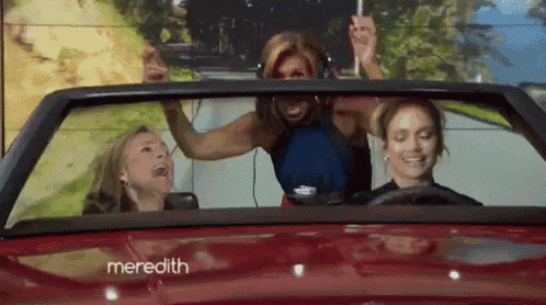 three women are sitting in a red car with meredith written on the side