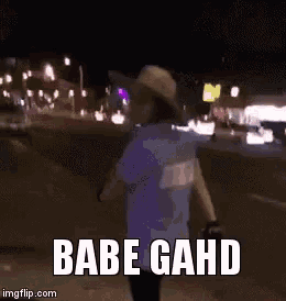 a woman in a cowboy hat is dancing in a parking lot with the words babe gahd above her .