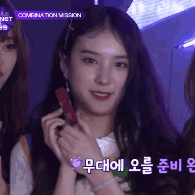 a girl holding a red lipstick in front of a combination mission sign