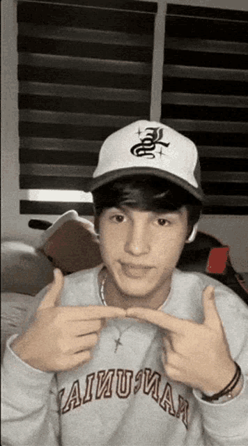 a young man wearing a white hat and a sweater that says ' aiuman ' on it