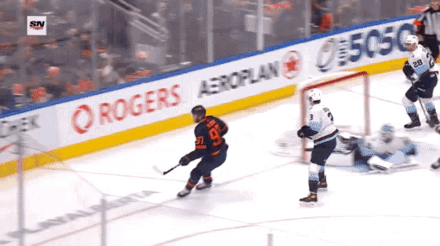 a hockey game is being played in front of a banner for rogers aeroplan