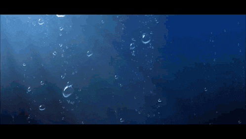 a man with a tattoo on his arm is standing in the water with his hands outstretched